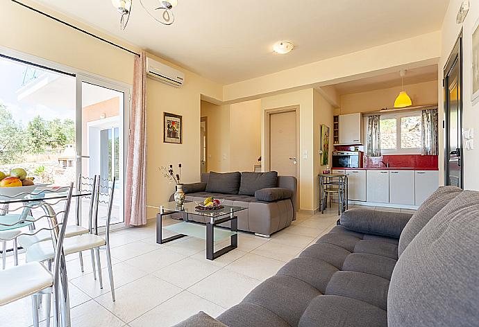 Open-plan living room with sofas, dining area, kitchen, A/C, WiFi internet, and satellite TV  . - Villa Eri . (Galería de imágenes) }}