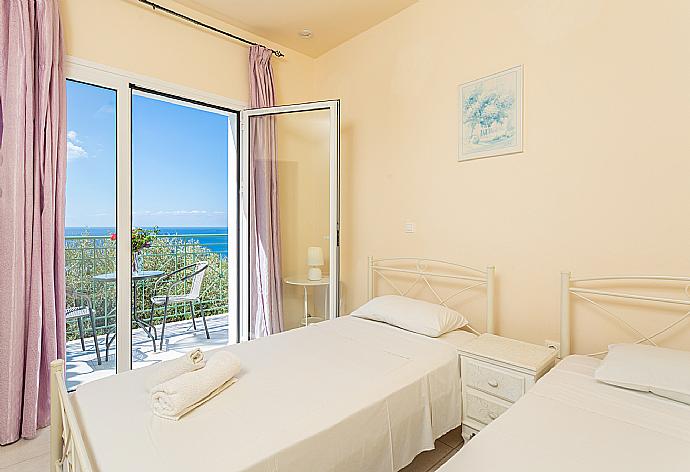 Twin bedroom with en suite bathroom, A/C, and upper terrace access with panoramic sea views . - Villa Eri . (Galerie de photos) }}