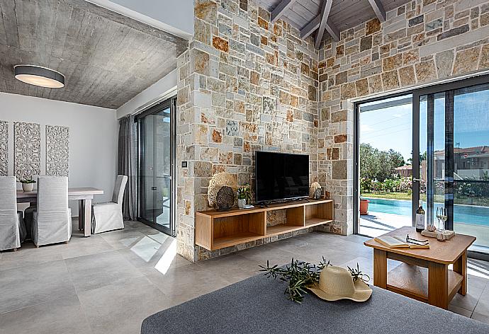 Open-plan living room with sofas, dining area, kitchen, A/C, WiFi internet, satellite TV, and pool terrace access . - Villa Angelos . (Galerie de photos) }}