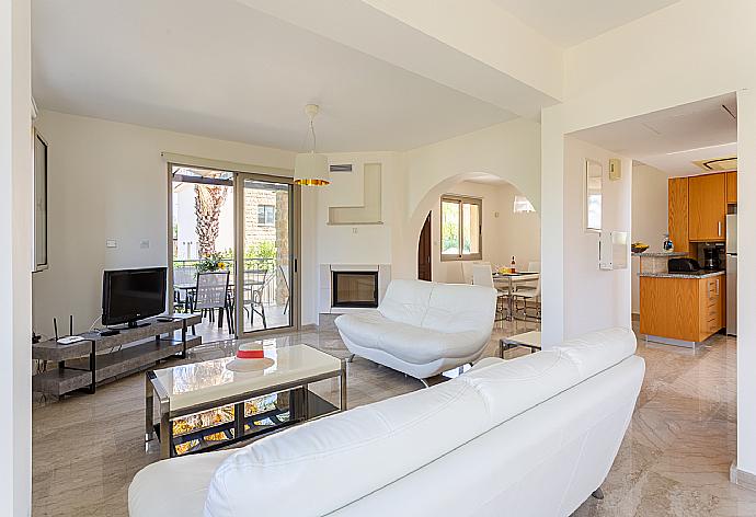 Open-plan living room with sofas, dining area, kitchen, ornamental fireplace, A/C, WiFi internet, and TV  . - Villa Izabella . (Fotogalerie) }}