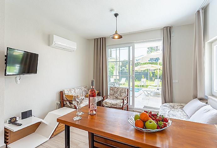 Open-plan living room with sofas, kitchen, A/C, WiFi internet, satellite TV, and pool terrace access . - Villa Zonkdemir . (Fotogalerie) }}