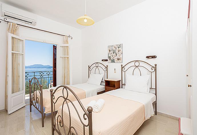 Twin bedroom with A/C and balcony access with sea views . - Villa Ilios . (Photo Gallery) }}