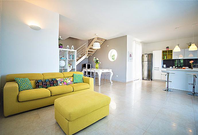 Open-plan living room with sofa, dining area, kitchen, A/C, WiFi internet, and satellite TV . - Villa Orchidea . (Fotogalerie) }}