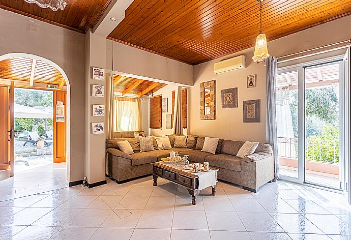 Open-plan living room with sofas, dining area, kitchen, ornamental fireplace, A/C, WiFi internet, and satellite TV . - Dimitris Cottage . (Galerie de photos) }}