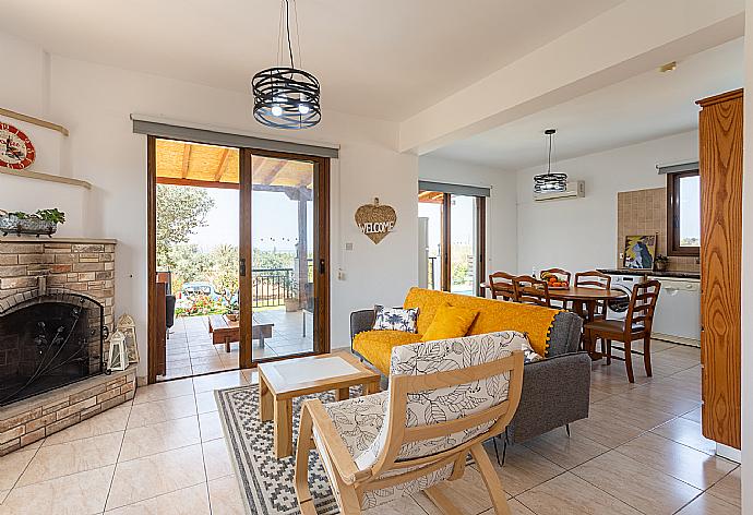 Open-plan living room with sofa, dining area, kitchen, ornamental fireplace, A/C, WiFi internet, satellite TV, and terrace access with sea views . - Villa Sunset . (Fotogalerie) }}