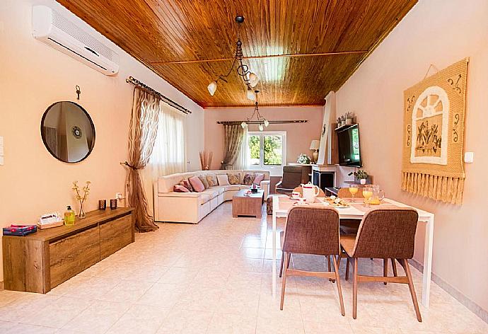 Open plan living room with A/C, TV, ornamental fireplace and dining table . - Villa Michael . (Fotogalerie) }}