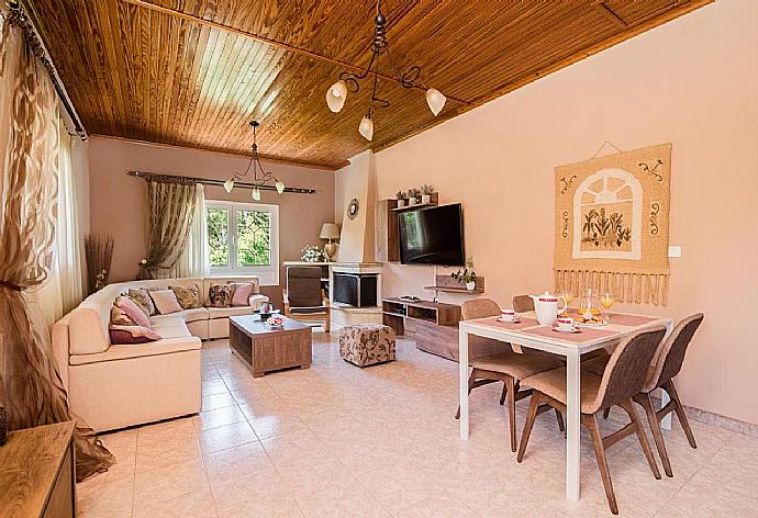 Open plan living room with A/C, TV, ornamental fireplace and dining table . - Villa Michael . (Galería de imágenes) }}