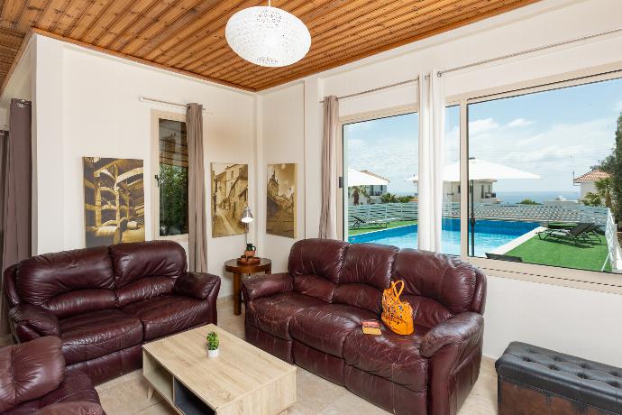 Open-plan living room with sofas, dining area, kitchen, WiFi internet, satellite TV, and sea views . - Villa Aristotle . (Fotogalerie) }}