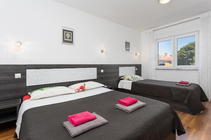 Bedroom (double bed and single bed) with en suite bathroom, A/C, and TV . - Villa Krnica . (Galleria fotografica) }}