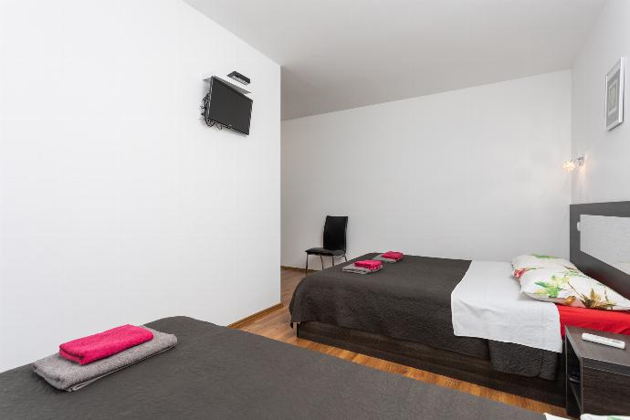 Bedroom (double bed and single bed) with en suite bathroom, A/C, and TV . - Villa Krnica . (Photo Gallery) }}