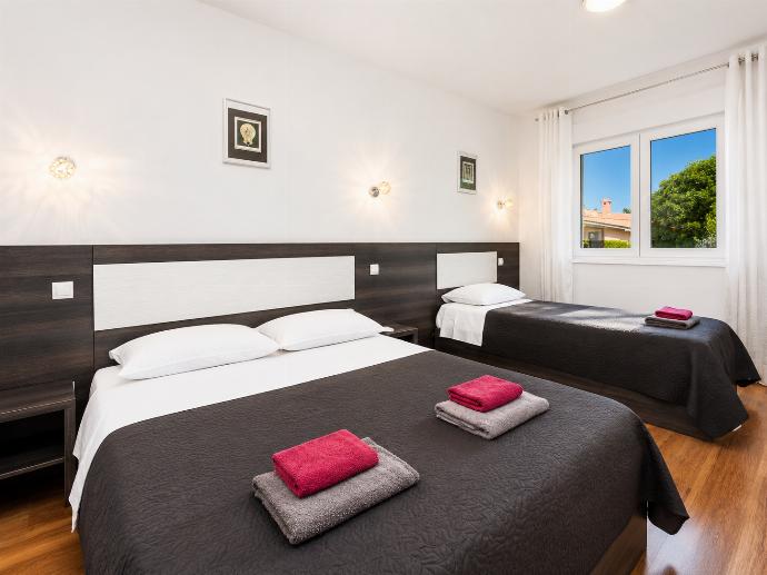 Bedroom (double bed and single bed) with en suite bathroom, A/C, and TV . - Villa Krnica . (Photo Gallery) }}