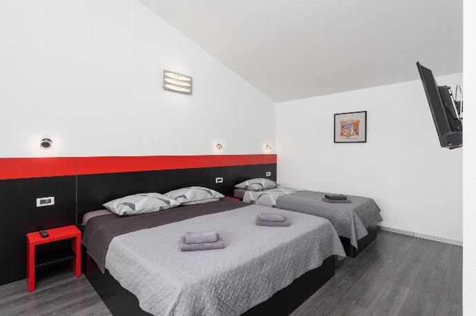 Bedroom (double bed and single bed) with en suite bathroom, A/C, and TV . - Villa LM . (Galerie de photos) }}