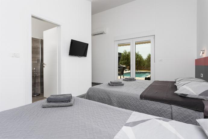 Bedroom (double bed and single bed) with en suite bathroom, A/C, and TV . - Villa LM . (Galleria fotografica) }}