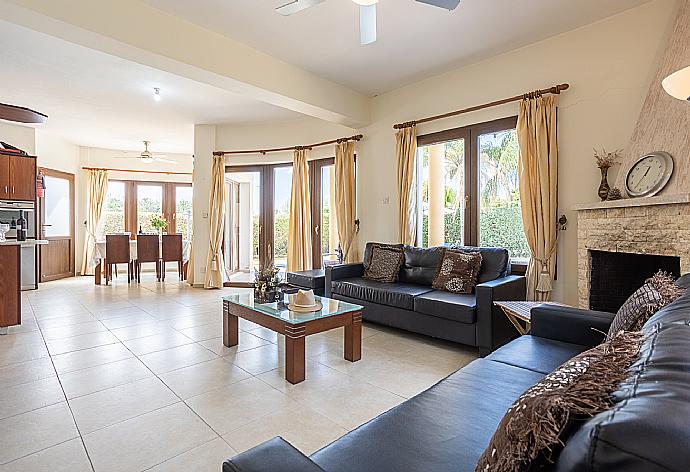 Open-plan living room with sofas, dining area, kitchen, ornamental fireplace, A/C, WiFi internet, and satellite TV . - Villa Tsikkos Ena . (Галерея фотографий) }}