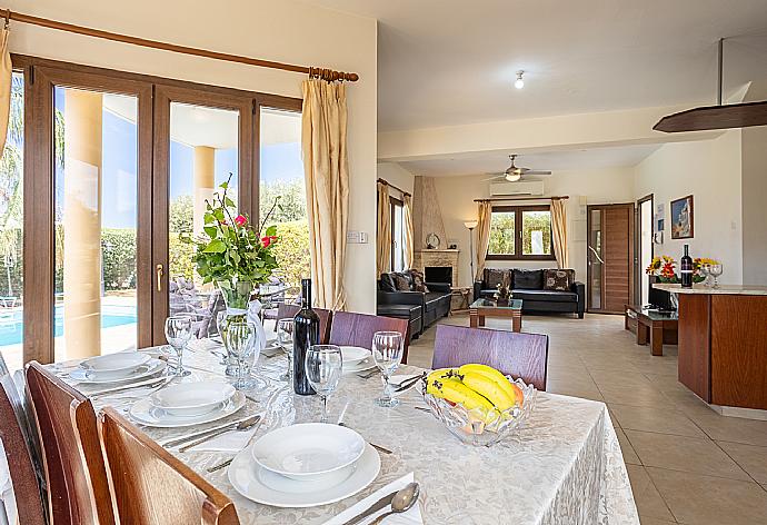 Open-plan living room with sofas, dining area, kitchen, ornamental fireplace, A/C, WiFi internet, and satellite TV . - Villa Tsikkos Ena . (Fotogalerie) }}