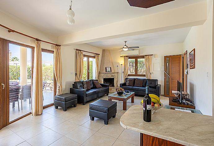 Open-plan living room with sofas, dining area, kitchen, ornamental fireplace, A/C, WiFi internet, and satellite TV . - Villa Tsikkos Tessera . (Galleria fotografica) }}