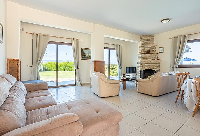 Open-plan living room with sofas, dining area, kitchen, ornamental fireplace, A/C, WiFi internet, satellite TV, and sea views . - Blue Bay Villa Nicole . (Galería de imágenes) }}