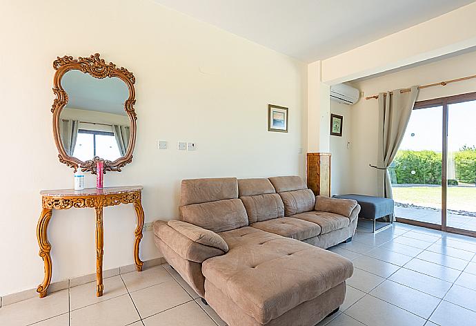 Open-plan living room with sofas, dining area, kitchen, ornamental fireplace, A/C, WiFi internet, satellite TV, and sea views . - Blue Bay Villa Nicole . (Fotogalerie) }}