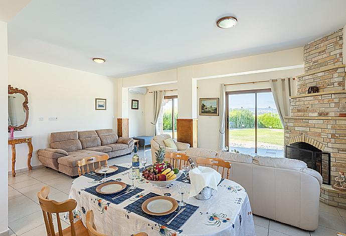 Open-plan living room with sofas, dining area, kitchen, ornamental fireplace, A/C, WiFi internet, satellite TV, and sea views . - Blue Bay Villa Nicole . (Fotogalerie) }}