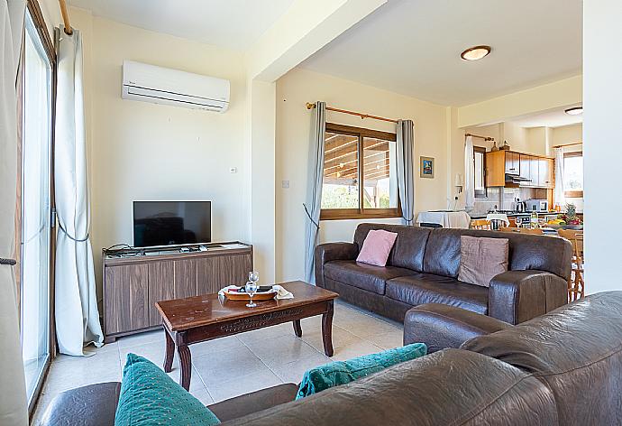 Open-plan living room with sofas, dining area, kitchen, A/C, WiFi internet, satellite TV, and sea views . - Blue Bay Villa Thea . (Fotogalerie) }}