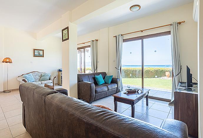 Open-plan living room with sofas, dining area, kitchen, A/C, WiFi internet, satellite TV, and sea views . - Blue Bay Villa Thea . (Fotogalerie) }}