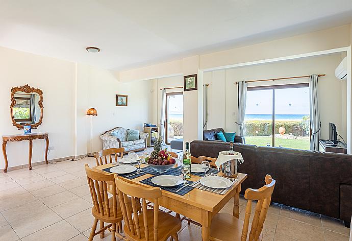 Open-plan living room with sofas, dining area, kitchen, A/C, WiFi internet, satellite TV, and sea views . - Blue Bay Villa Thea . (Fotogalerie) }}