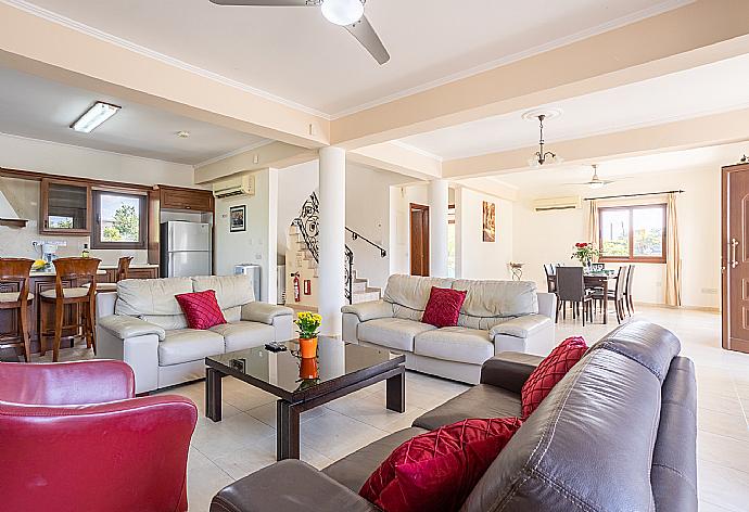 Open-plan living room with sofas, dining area, kitchen, ornamental fireplace, A/C, WiFi internet, and satellite TV . - Villa Dora . (Galería de imágenes) }}