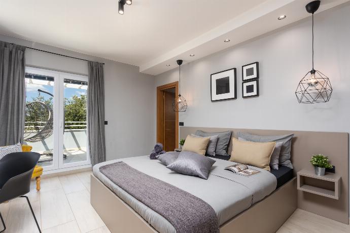 Double bedroom with en suite bathroom, A/C, TV, and balcony access . - Villa Ovis . (Galerie de photos) }}