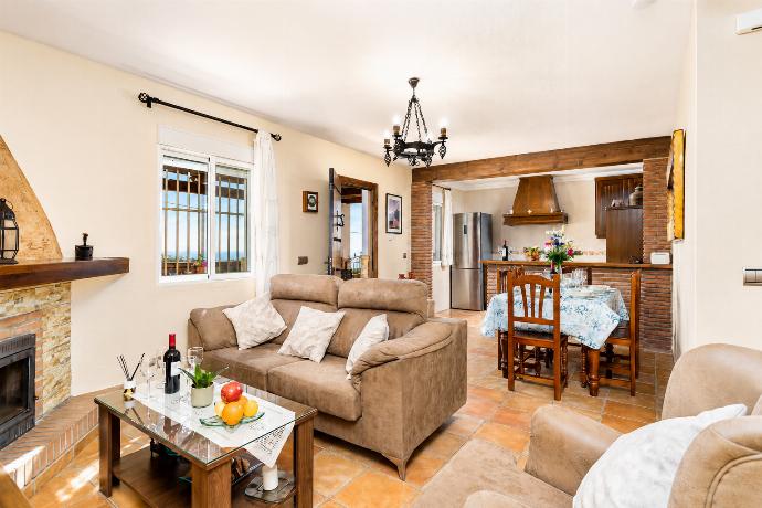 Open-plan living room with sofas, dining area, kitchen, ornamental fireplace, WiFi internet, satellite TV, and sea views . - Villa Ana y Garcia . (Photo Gallery) }}