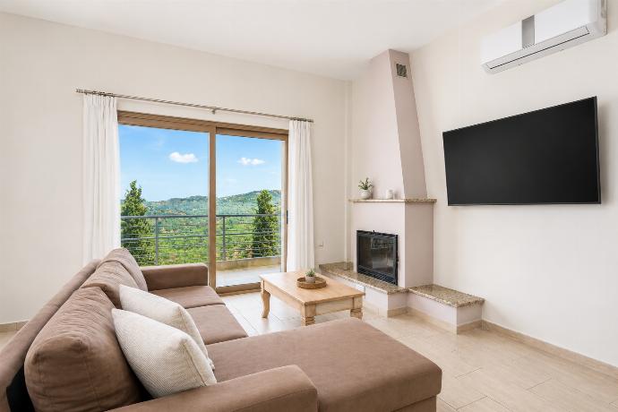 Open-plan living room with sofa, dining area, kitchen, ornamental fireplace, A/C, WiFi internet, and satellite TV . - Stefania Villa Ena . (Galería de imágenes) }}