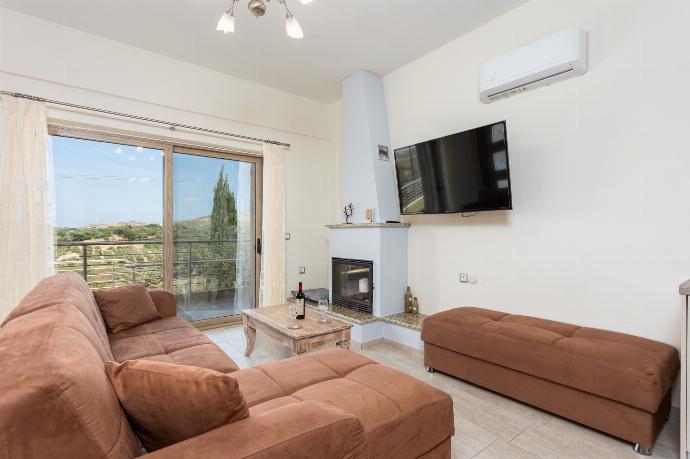 Open-plan living room with sofa, dining area, kitchen, ornamental fireplace, A/C, WiFi internet, and satellite TV . - Stefania Villa Dio . (Galleria fotografica) }}