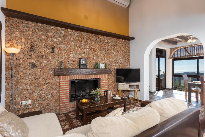 Open-plan living room with sofas, dining area, kitchen, ornamental fireplace, A/C, WiFi internet, satellite TV, and sea views . - Villa Cortijo El Amigo . (Galería de imágenes) }}