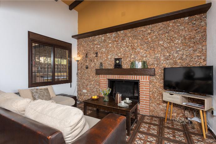 Open-plan living room with sofas, dining area, kitchen, ornamental fireplace, A/C, WiFi internet, satellite TV, and sea views . - Villa Cortijo El Amigo . (Fotogalerie) }}