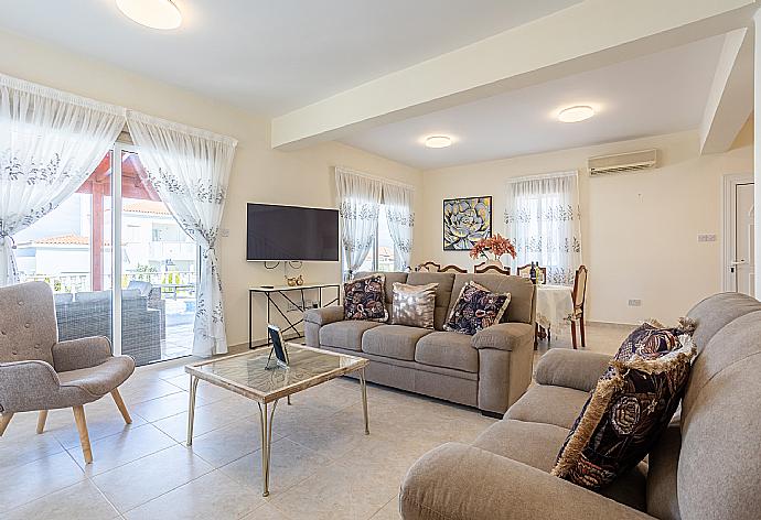 Open-plan living room with sofas, dining area, kitchen, ornamental fireplace, A/C, WiFi internet, and satellite TV . - Villa Amore . (Fotogalerie) }}