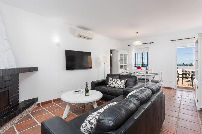 Open-plan living room with sofas, dining area, kitchen, ornamental fireplace, A/C, WiFi internet, satellite TV, and sea views . - Villa Casa Gebemir . (Fotogalerie) }}