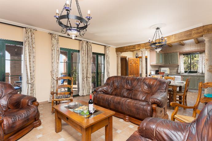 Open-plan living room with sofas, dining area, kitchen, ornamental fireplace, A/C, WiFi internet, satellite TV, and sea views . - Villa El Pedregal . (Photo Gallery) }}