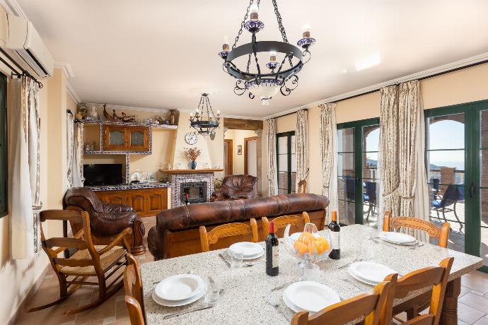 Open-plan living room with sofas, dining area, kitchen, ornamental fireplace, A/C, WiFi internet, satellite TV, and sea views . - Villa El Pedregal . (Galería de imágenes) }}