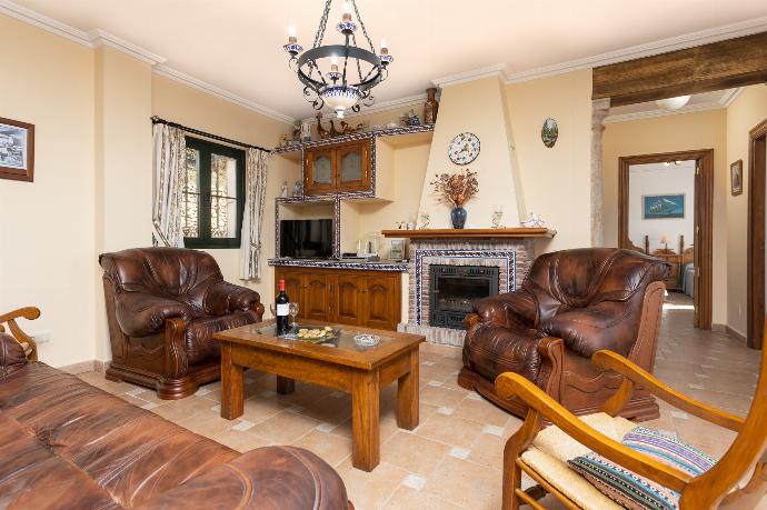 Open-plan living room with sofas, dining area, kitchen, ornamental fireplace, A/C, WiFi internet, satellite TV, and sea views . - Villa El Pedregal . (Fotogalerie) }}