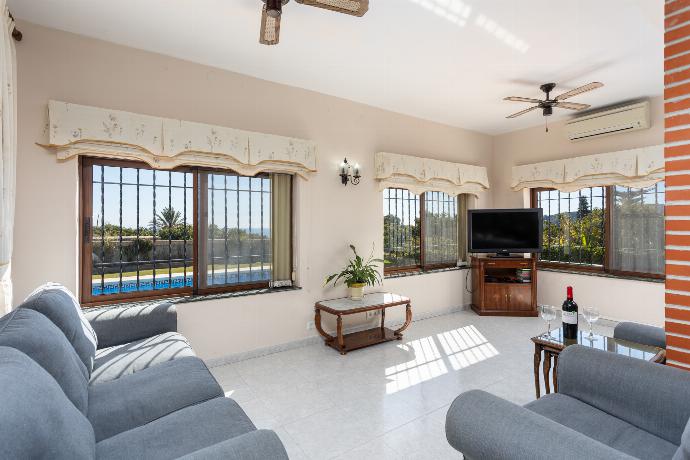 Open-plan living room with sofas, dining area, kitchen, ornamental fireplace, A/C, WiFi internet, satellite TV, and sea views . - Villa Alta Vista . (Photo Gallery) }}