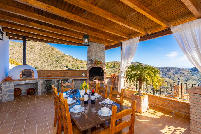 Sheltered terrace area with BBQ and wood-fired oven . - Villa Flores . (Galerie de photos) }}