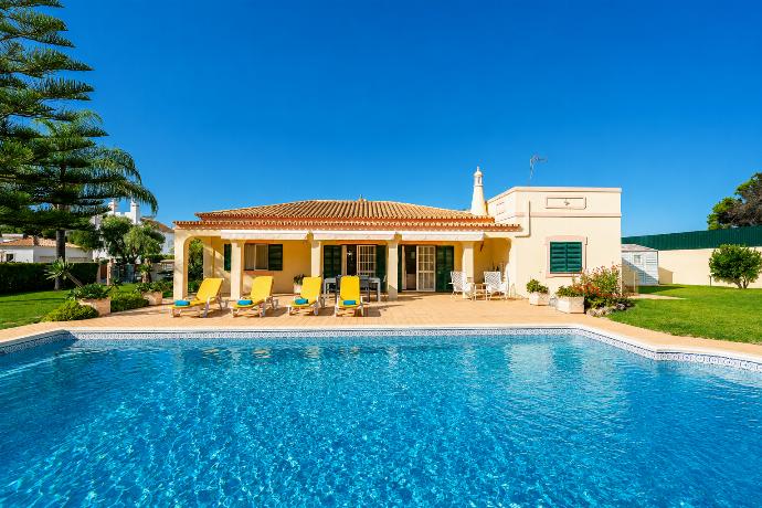 Beautiful single-story villa with a large swimming pool, tiled patio, and yellow lounge chairs. . - Villa Green Palms . (Photo Gallery) }}