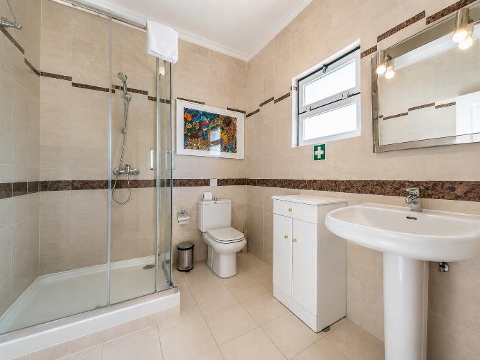 Tiled bathroom featuring a glass shower stall, pedestal sink, and small vanity cabinet. . - Villa Green Palms . (Photo Gallery) }}