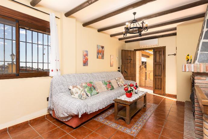 Open-plan living room with sofa, dining area, kitchen, ornamental fireplace, A/C, WiFi internet, and satellite TV . - Villa Las Palomas 2 . (Galleria fotografica) }}