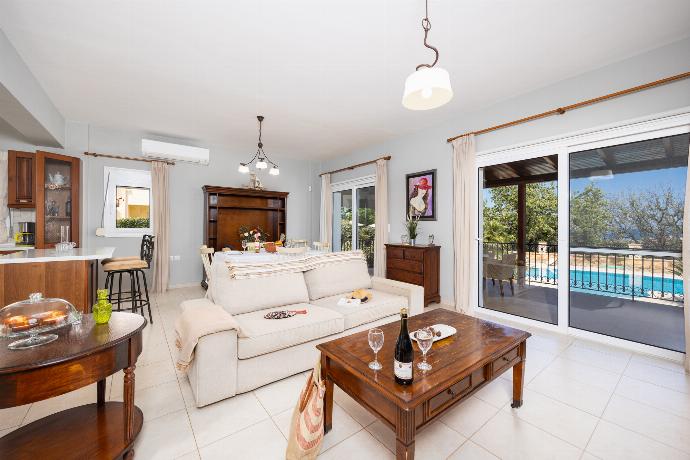 Open-plan living room with sofa, dining area, kitchen, ornamental fireplace, A/C, WiFi internet, and satellite TV . - Villa Chloe . (Photo Gallery) }}