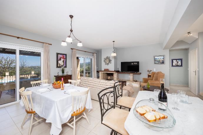 Open-plan living room with sofa, dining area, kitchen, ornamental fireplace, A/C, WiFi internet, and satellite TV . - Villa Chloe . (Photo Gallery) }}