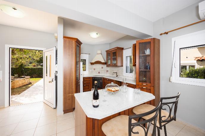 Open-plan living room with sofa, dining area, kitchen, ornamental fireplace, A/C, WiFi internet, and satellite TV . - Villa Chloe . (Photo Gallery) }}