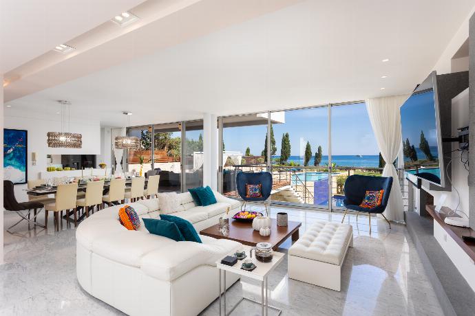 Open-plan living room on first floor with sofa, dining area, kitchen, ornamental fireplace, A/C, WiFi internet, satellite TV, and sea views . - Annabel Beach Palace . (Galleria fotografica) }}