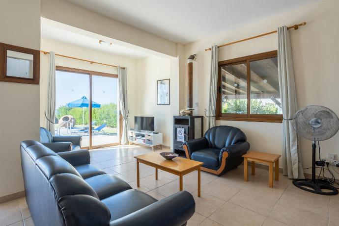 Open-plan living room with sofas, dining area, kitchen, ornamental fireplace, A/C, WiFi internet, satellite TV, and sea views . - Blue Bay Villas Collection . (Галерея фотографий) }}