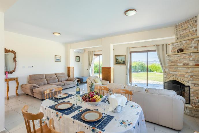 Open-plan living room with sofas, dining area, kitchen, ornamental fireplace, A/C, WiFi internet, satellite TV, and sea views . - Blue Bay Villas Collection . (Galería de imágenes) }}