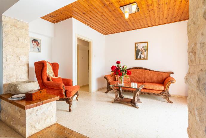 Open-plan living room with sofas, dining area, kitchen, ornamental fireplace, A/C, WiFi internet, satellite TV, and terrace access . - Androula Villas Collection . (Fotogalerie) }}